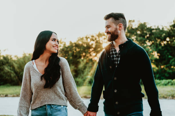 istock Beautiful happy affectionate couple hold hands and walk together outdoors at dusk in the fall 1488457003