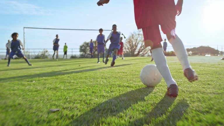 Soccer, sport and running with kids playing on a field during a competitive team game in summer. Exercise, football and fitness with a group of children outdoor scoring a goal during a competition