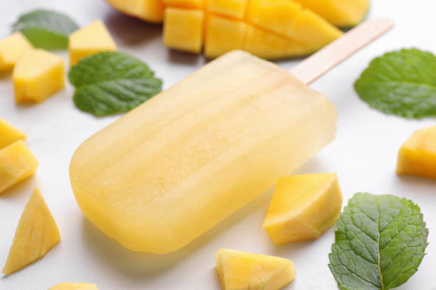 istock Tasty mango ice pop on white table, closeup. Fruit popsicle 1488464927