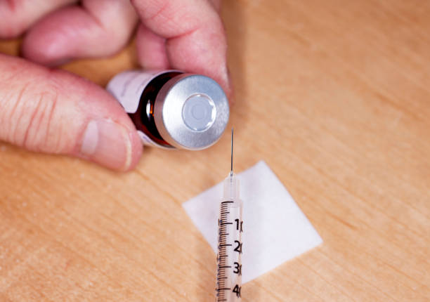 istock Close up of handheld  unopened needle and syringe 1488474781