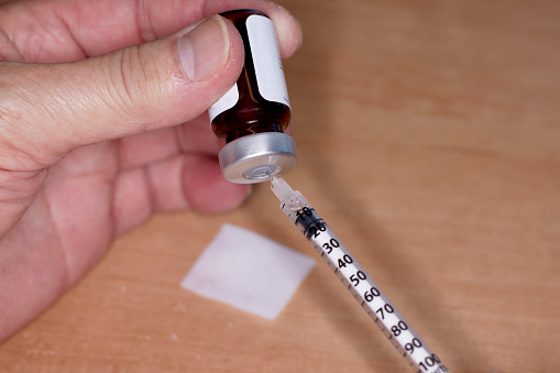 Close up of handheld   needle and syringe with Testosterone Vial