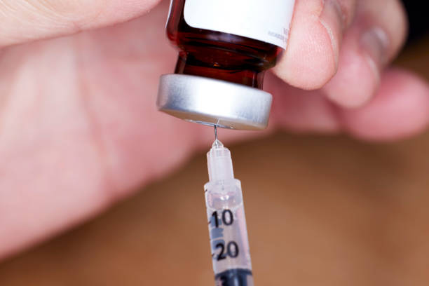 istock Close up of handheld   needle and syringe with Testosterone Vial 1488475307
