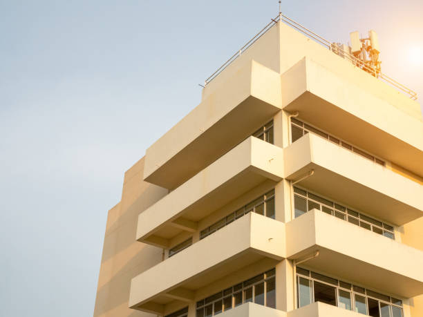 istock side view of yellow concrete building Intersect the orange sun. 1488475775