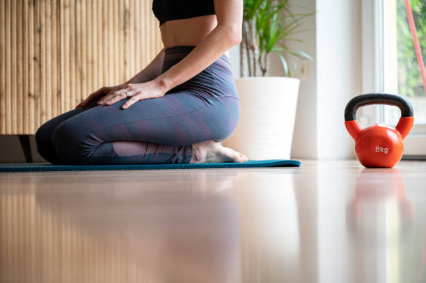 istock Fit woman sitting on an exercise mat taking a break from a workout 1488477669