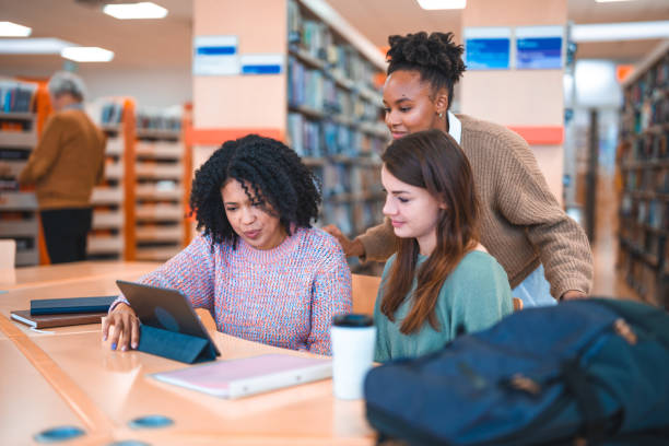 istock Diverse Females Using Digital Tablet In A Library 1488481093