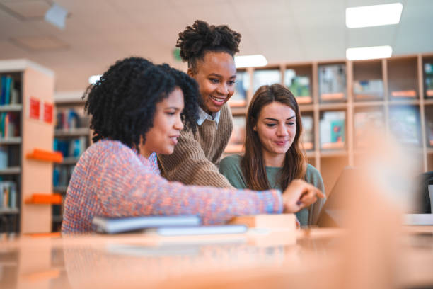 istock Diverse Females Using Digital Tablet In A Library 1488481097