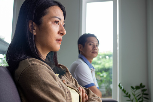 Asian women are disappointed and saddened after an argument with their husband. Asian couples are having family problems resulting in divorce. Love problem