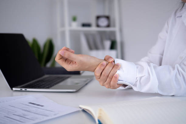 istock Businesswoman hurts wrist while working. A woman uses a computer for a long time causing Trigger Finger. Office Syndrome Concept. 1488488593