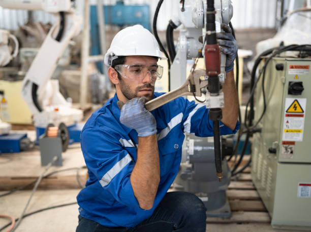 istock Caucasian technician engineer man with checking and repair machine arm robot at factory 1488489738