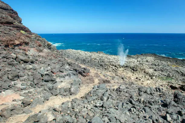 Photo of Dragons nostrils blowhole spewing seawater next to hiking trail at the popular Makapuu tidepools on the north shore of Oahu Hawaii United States