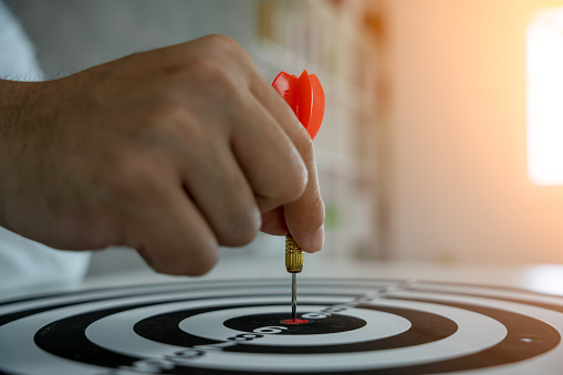 Businessman set goals for work. Hand holding a dart aiming at the target center business. goal, aiming marketing target metaphor, Succeed dart board, defines objectives, success investment ideas.