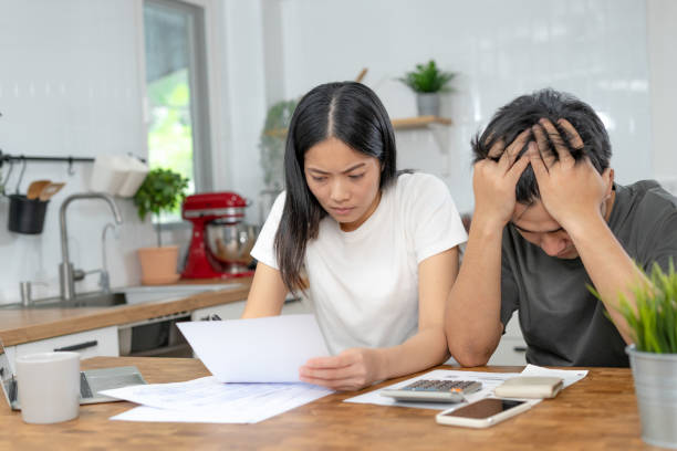 Asian couples managing debt and expenses. Husband and wife stressed over credit card bills and home electricity bills. Broke, mortgage, loan, bankruptcy, no money, bankruptcy, can't pay. parejas asiáticas gestionando deudas y gastos. el esposo y la esposa se estresaron por las facturas de tarjetas de crédito y las facturas de electricidad del hogar. quiebra, hipoteca, préstamo, bancarrota, sin dinero, bancarrota, no puedo pagar.