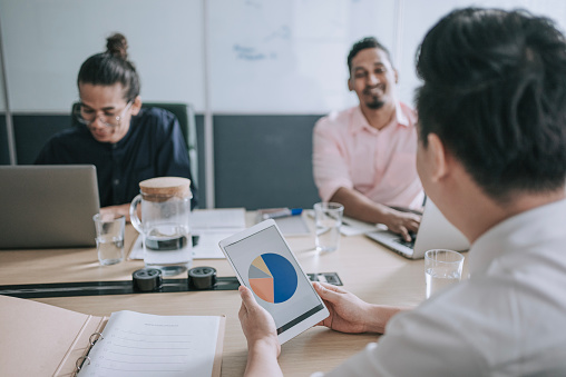 Diversify Asian Multiracial business person discussion in meeting room with digital tablet