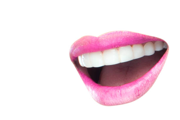 A cutout of a big red plumpy lips on wooden circle with a felt black background. Beauty concept