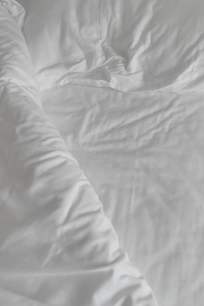 istock Texture of crumpled white bed sheets as background 1488502085