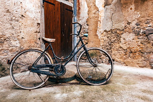 Abandoned vintage bicycle at street of old town of Lovran in Croatia, selective focus