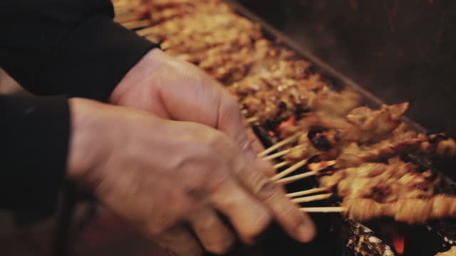 Man cooking grilling Satay