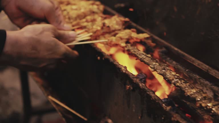 Man cooking grilling Satay