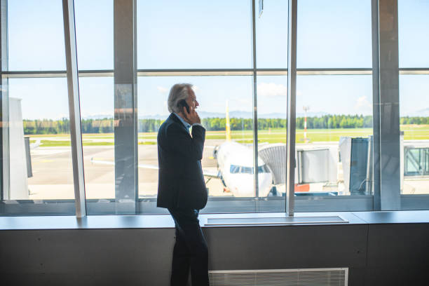 istock Departure Gates Corridor and an  Older Male Passenger Waiting While Using Smart Phone 1488507876