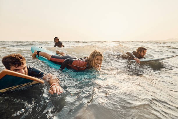 istock Cheerful friends having fun while surfing in sea. 1488514152