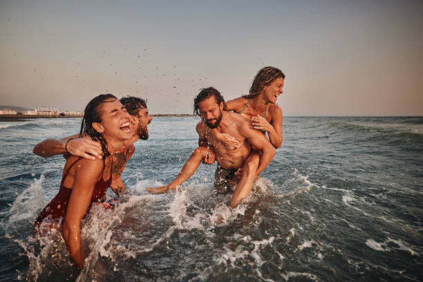 istock Young cheerful couples having fun during summer vacation in sea. 1488514365
