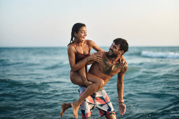 istock Cheerful couple having fun while piggybacking at sea. 1488514637