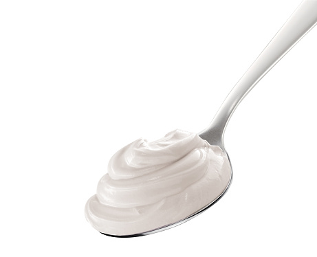 Yogurt on spoon, isolated on white background