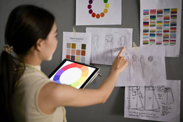 istock Creative fashion designer with her tablet checking new collection sketch design in her studio. 1488519019