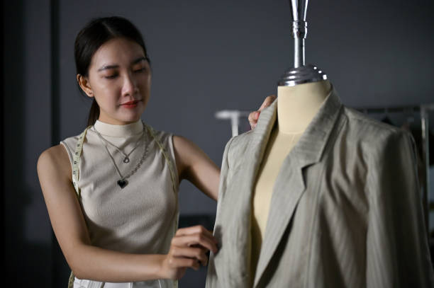 istock Beautiful Asian female fashion designer checking her pattern on a mannequin 1488519062