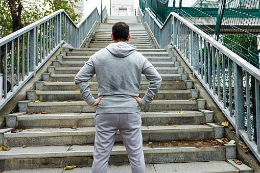 Young sporty man in sportswear preparing for stair run