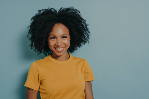 istock Happy dark skinned woman smiling at camera with pleased face expression, isolated on blue background 1488520660