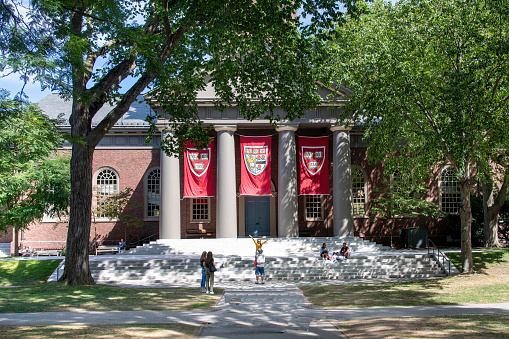 Boston, MA, USA-September 2022; View over Harvard Yard of Harvard University towards Memorial Church with university banners hanging between columns and students on steps