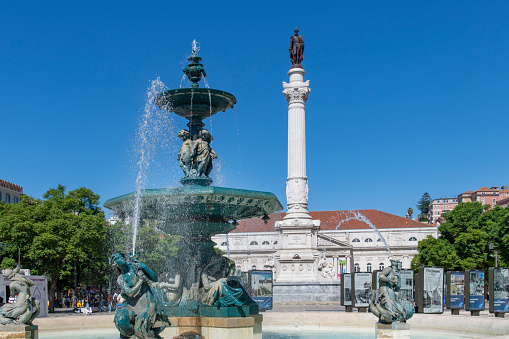 Lisbon, Portugal-October 2022: Close up view of Mermaid Statues and Fountains at Rossio Square (Pedro IV Square) with view on the Column of Pedro IV and the D. Maria II National Theatre