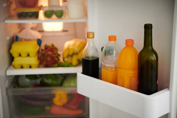 geöffneter kühlschrank mit flaschen - refrigerator healthy eating mango fruit stock-fotos und bilder