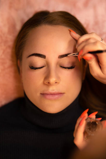 istock Beautician Applying Dye On Female Customer's Eyebrow 1488526743