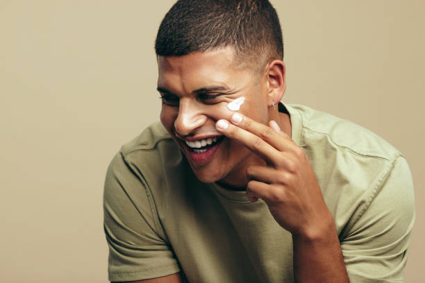 istock Young man using moisturizing facial cream on his flawless skin 1488528383