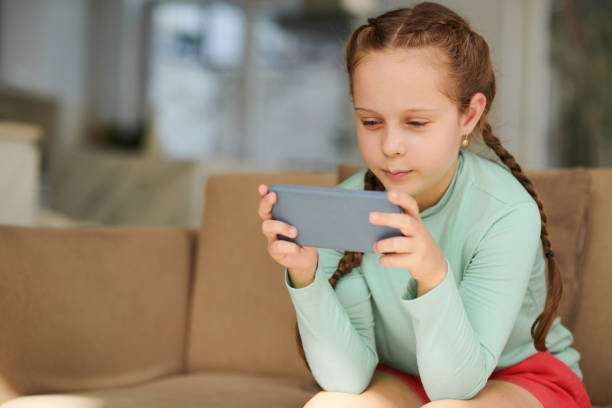 istock Joyful Girl Playing Game on Smartphone 1488529703