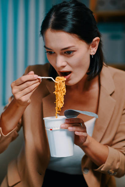 istock Businesswoman Eating Instant Ramen 1488530957
