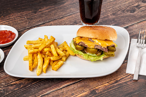 Delicious beef burger with french fries, onion rings and sauces