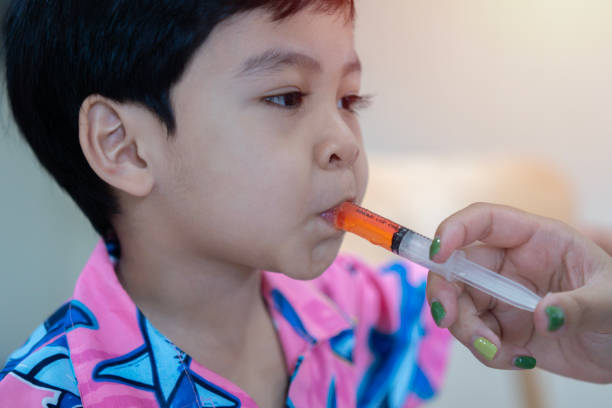 Baby Asian child take an oral medical suspension an ibuprofen by syringe Baby Asian child take an oral medical suspension an ibuprofen by syringe for relieving reduce pain fever and inflammation. medical care concept. child liquid medicine stock pictures, royalty-free photos & images
