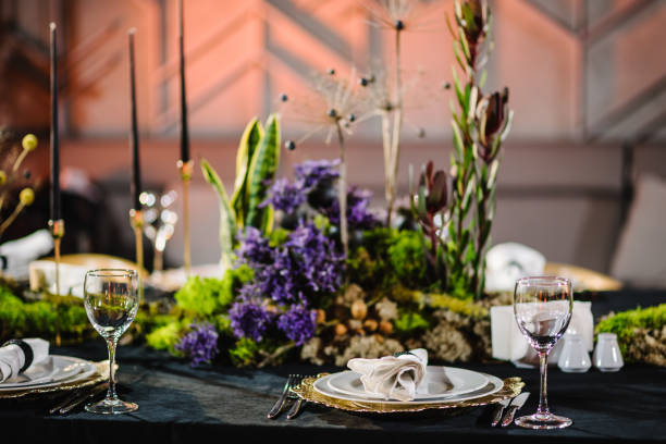 istock Wedding reception. Rustic. Composition of bark tree, wooden decor, moss in restaurant. Table decorated plates and glasses, candles, flowers, greenery. Interior of table for guests with natural decor. 1488532630