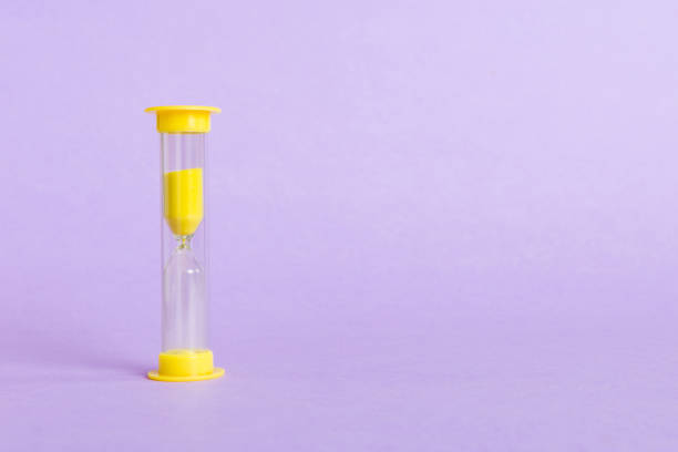 hourglass on the table, sand clock as time passing concept for business deadline, copy space - hourglass time purple deadline imagens e fotografias de stock