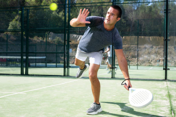 istock Athletic man plays padel. View through tennis net outdoor 1488533268