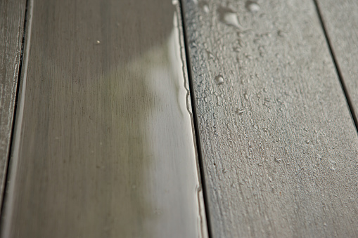 Close up of rain on wooden grey patio deck plank