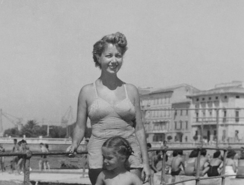 Mother and daughter enjoying a sunny day in tourist resort. 1954.
