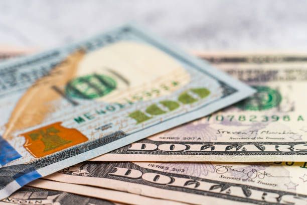 Fragment of hundred dollar banknote. Close-up american paper currancy bill. Selective focus Fragment of hundred dollar note. Close-up american paper currancy. Selective focus. New US paper banknote on pile of old bills. High quality photo one hundred dollar stamp stock pictures, royalty-free photos & images