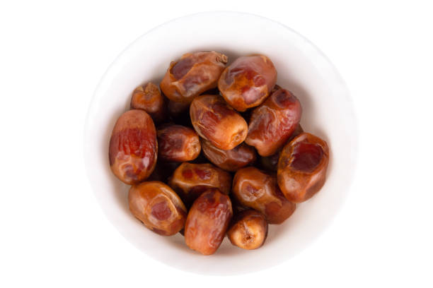 Dried dates in a plate isolated on a white background.