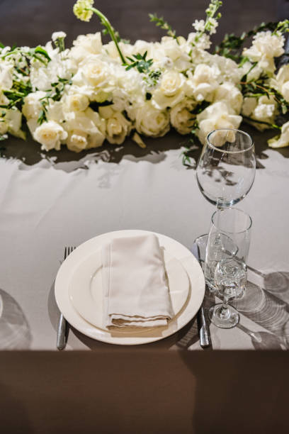 istock Wedding setup detail. Festive table covered tablecloth, decorated composition flowers and candles in party area. Table setting, serving. Banquet decoration in hall restaurant. Luxury reception. 1488539792