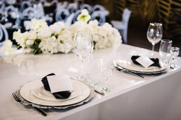 istock Serving, setting table. Plate decorated linen black napkin, postcard, silverware cutlery, glasses. Side view. Closeup. Wedding set up, dinner table reception. Birthday, baptism, event. 1488540555