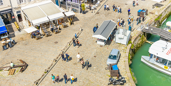 Tourists walking on the quayside of the Old Port of La Rochelle, France on a summer day